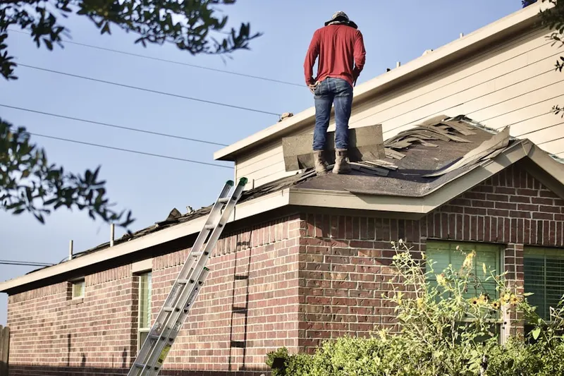 Professional roofer working on a residential roof in Stewartville